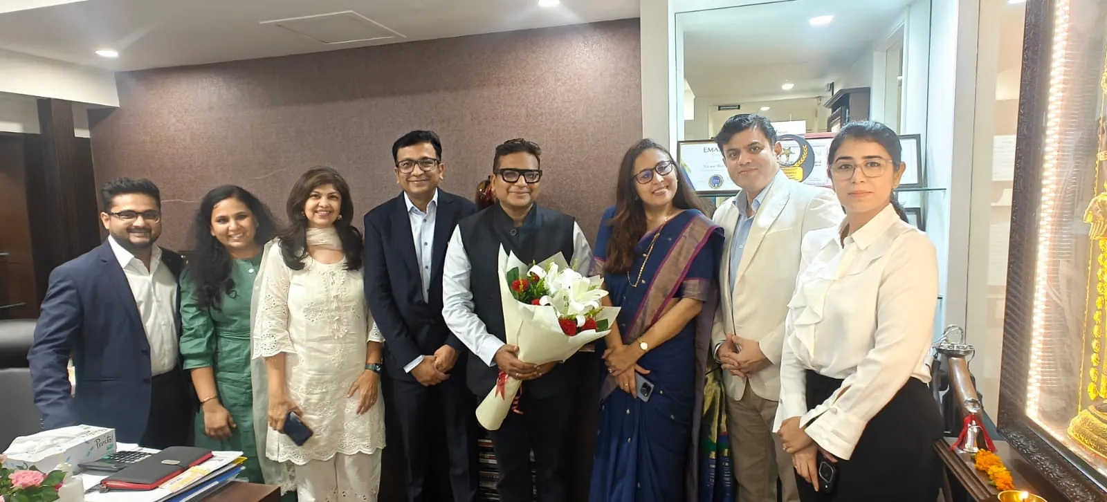 Members of the iVentures team gathered together with a bouquet in the office